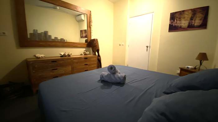 Chambre avec literie hibiscus et teck sculpté