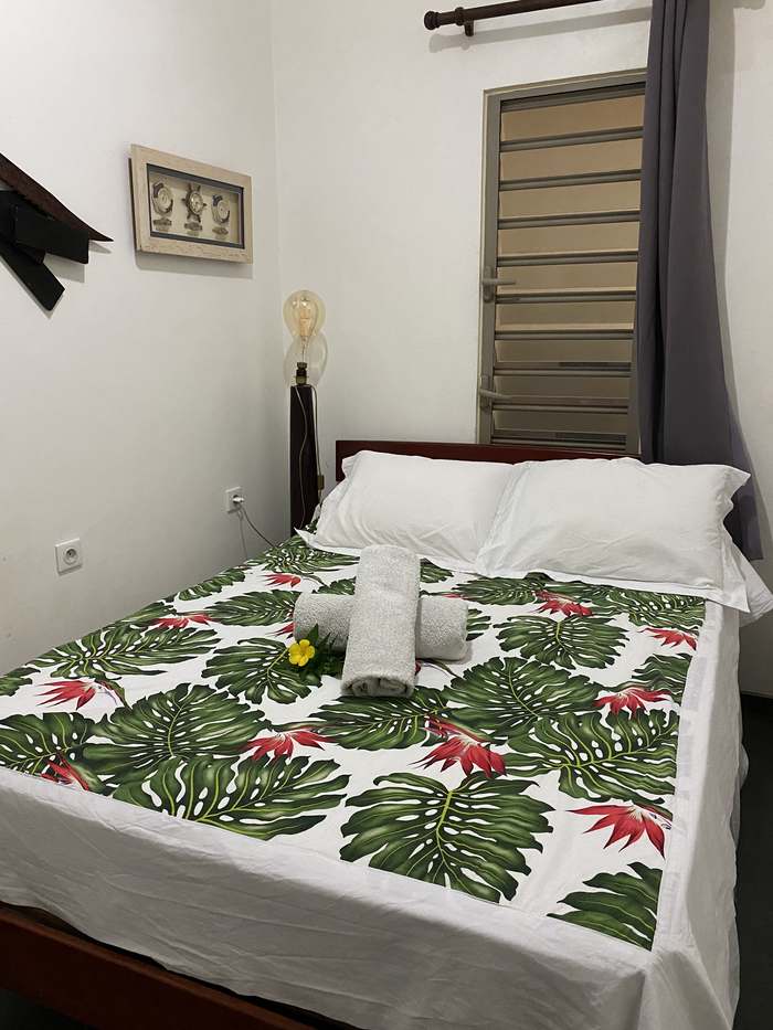Chambre Manta Villa avec literie hibiscus et miroir en teck sculpté